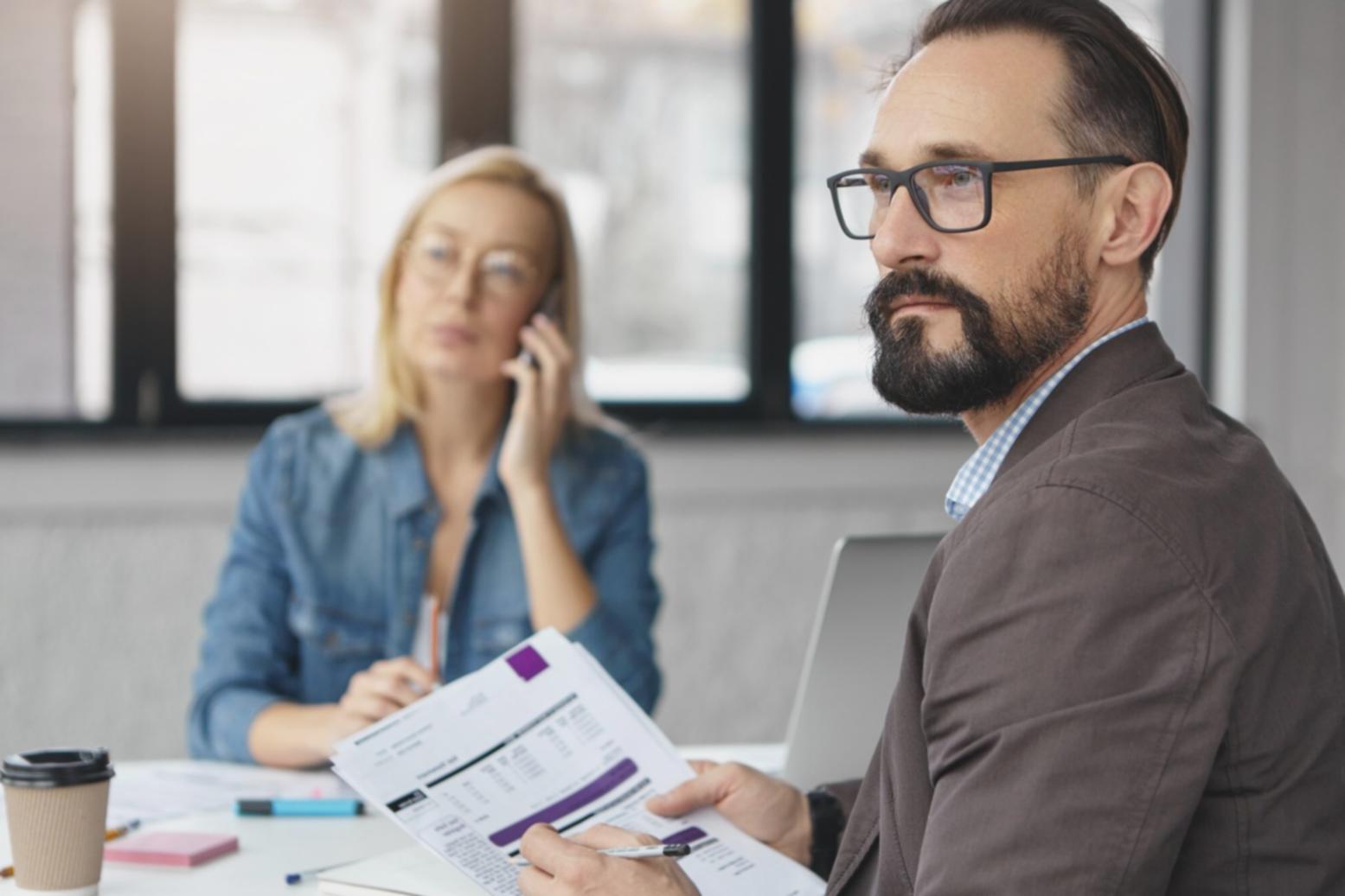 Professional business consultation meeting with financial documents and presentation materials